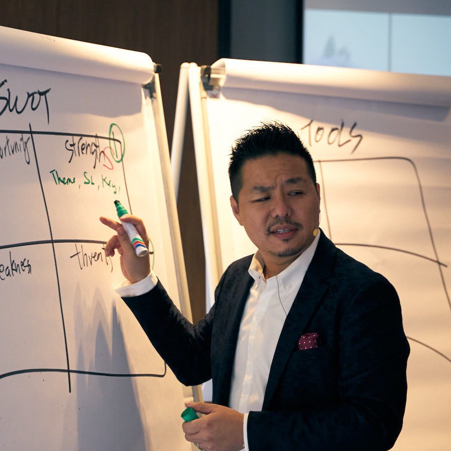 フリップチャートを指しながら講義する Dato' James Foo